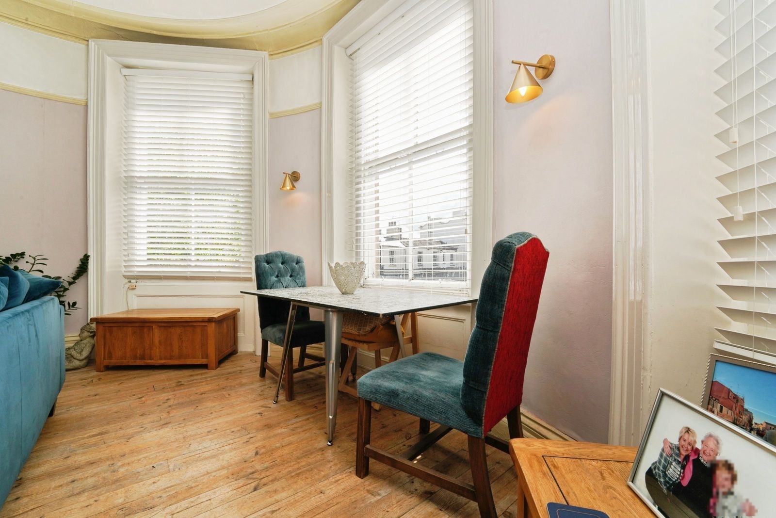 Dining table and upholstered chairs set into the window bay