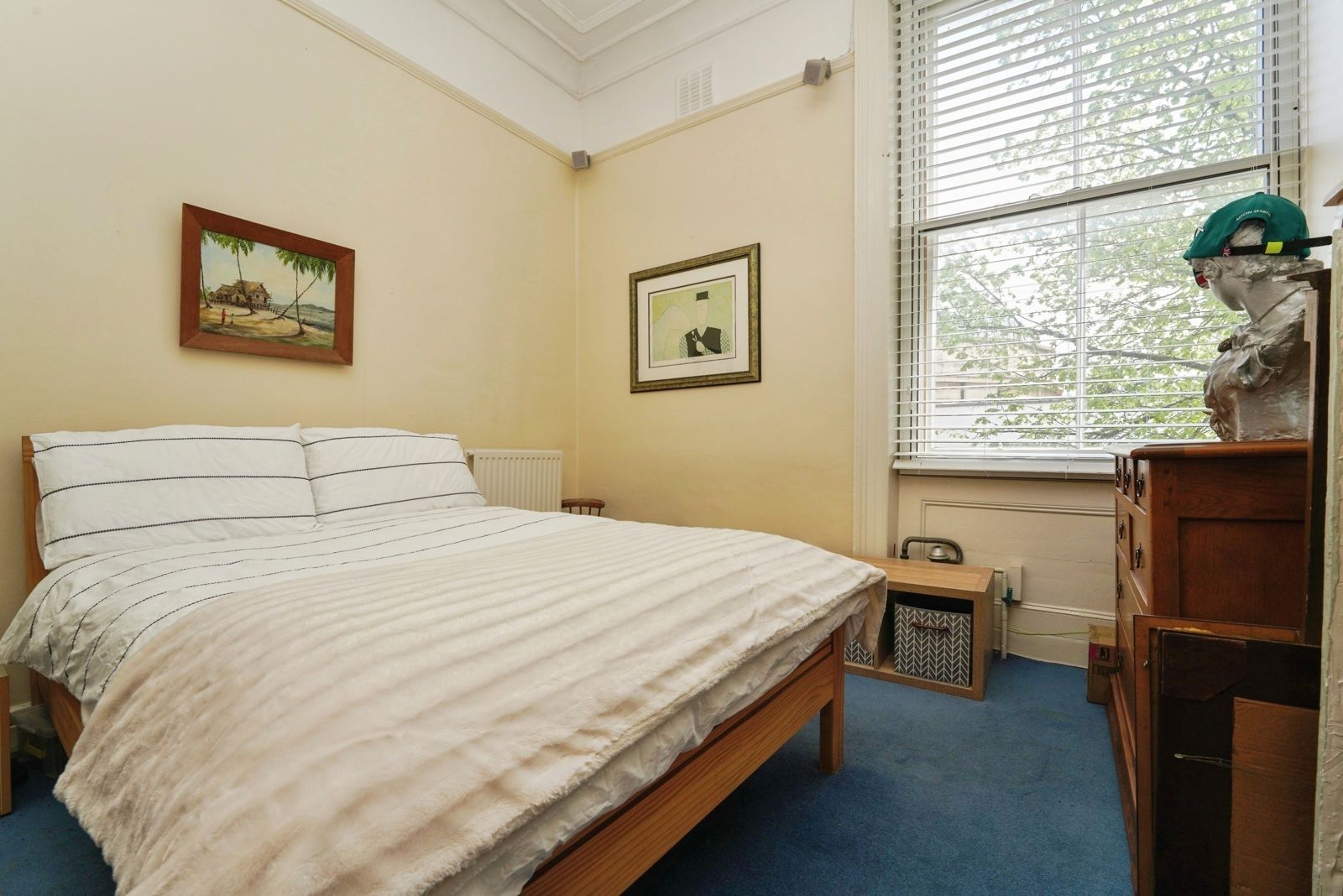 Double bedroom with a wooden bed frame and a tall sash window