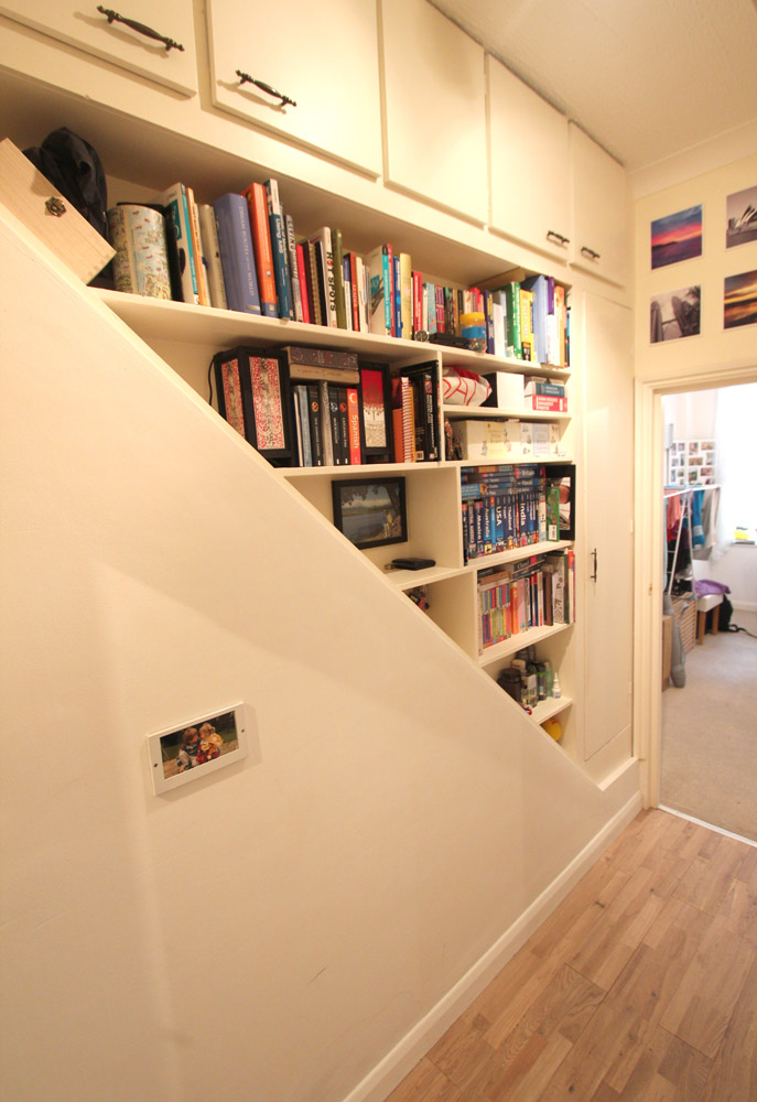 Hallway fitted floor to ceiling with built-in bookshelves and cupboards