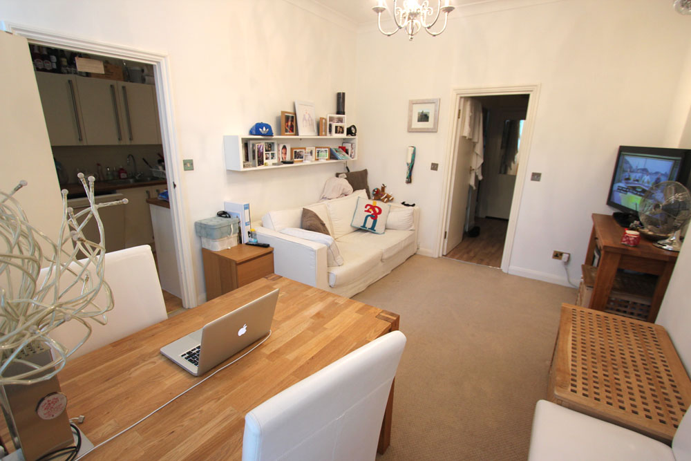 Living room from the opposite corner, with a desk and shelving