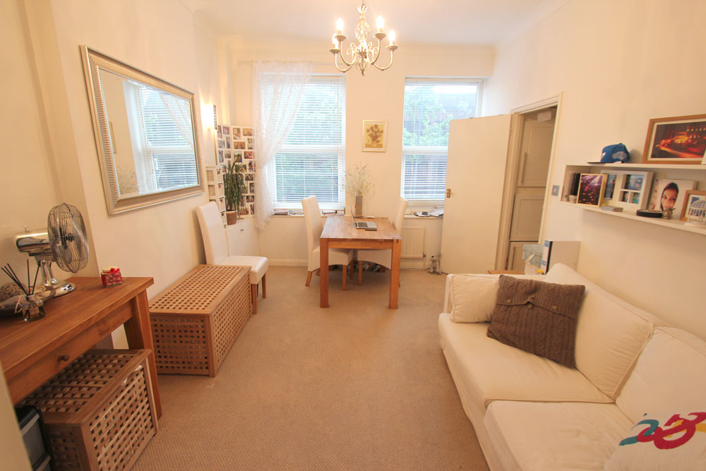 The living room at 386A Richmond Road, with two sash windows and pale walls